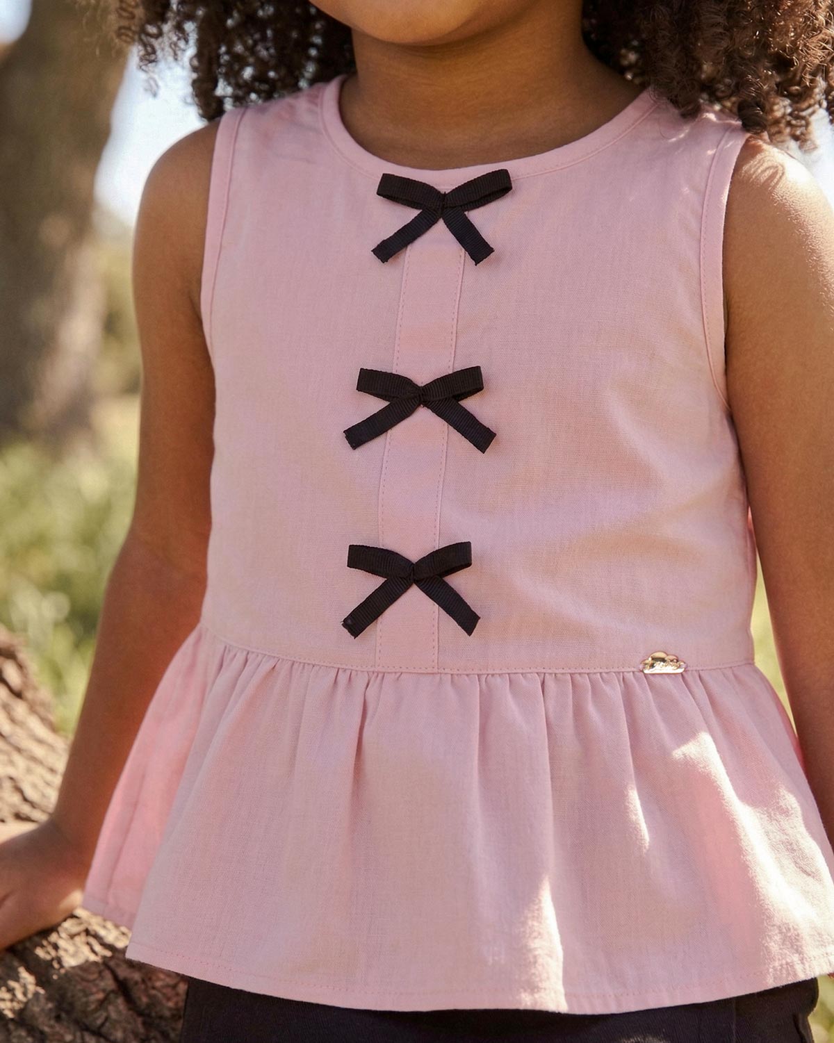Blusa rosa con moños negros para niña