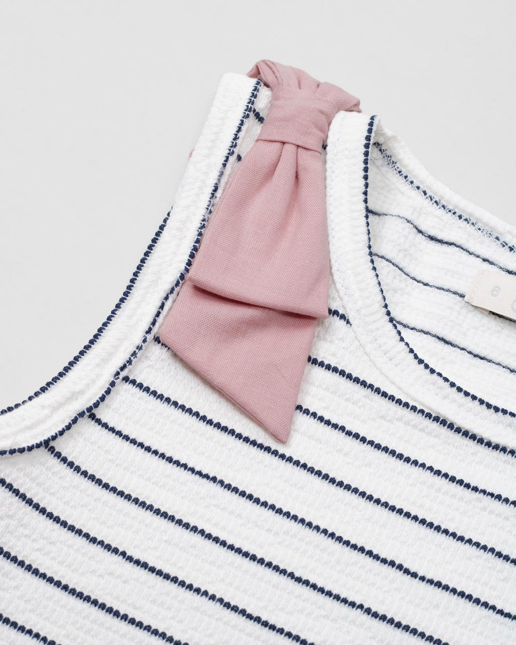Blusa manga sisa blanca con líneas y moño rosa para niña