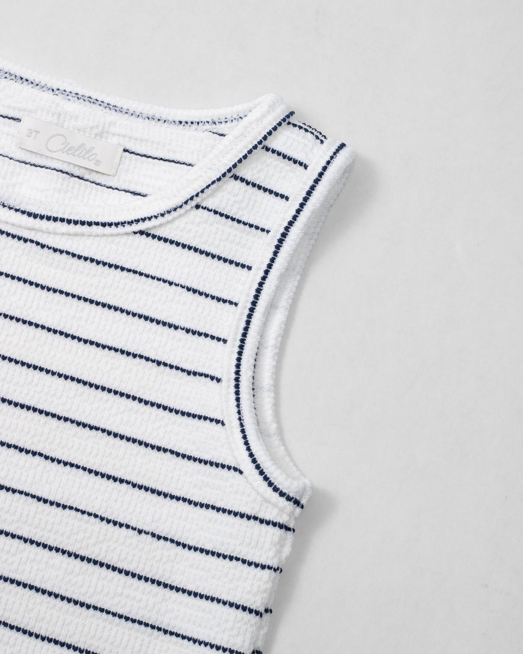 Blusa manga sisa blanca con líneas y moño rosa para niña
