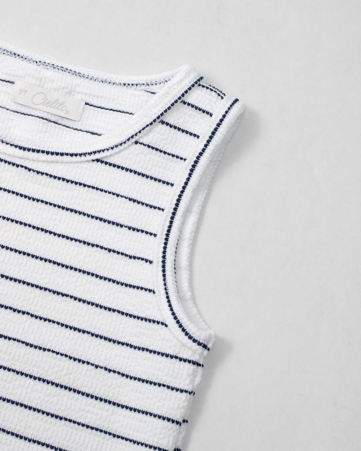 Blusa manga sisa blanca con líneas y moño rosa para niña