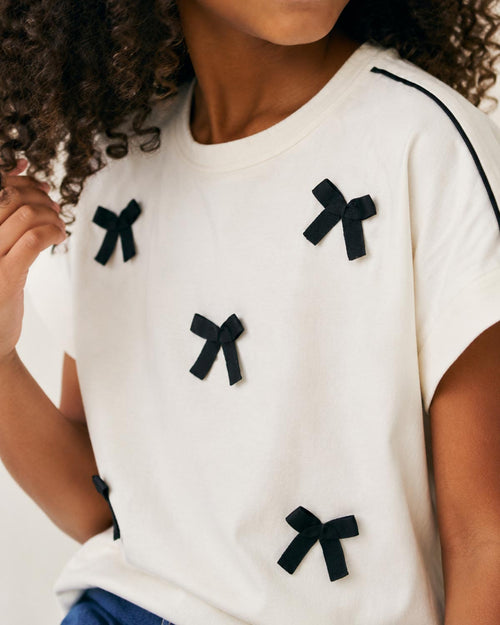 Blusa blanca con moñitos para niña