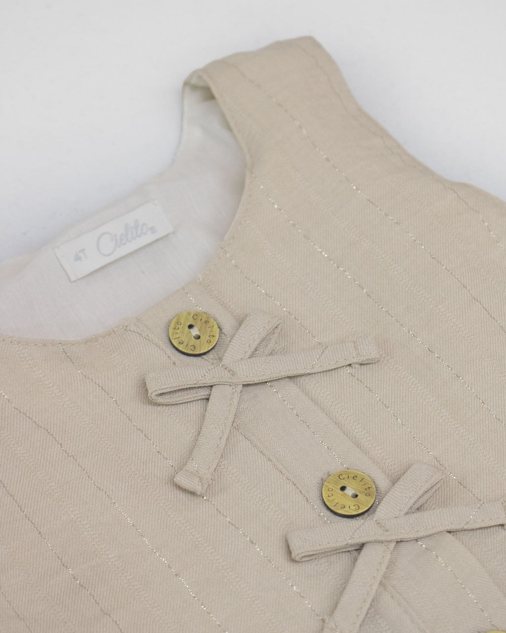 Blusa  beige con botones y moñitos para niña