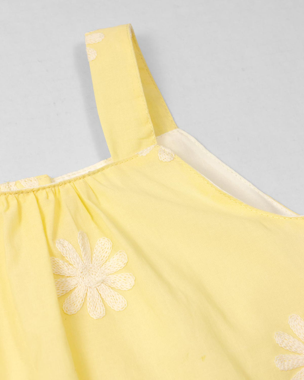 Blusa amarilla de tiras con bordados de flores y botonadura en espalda para niña