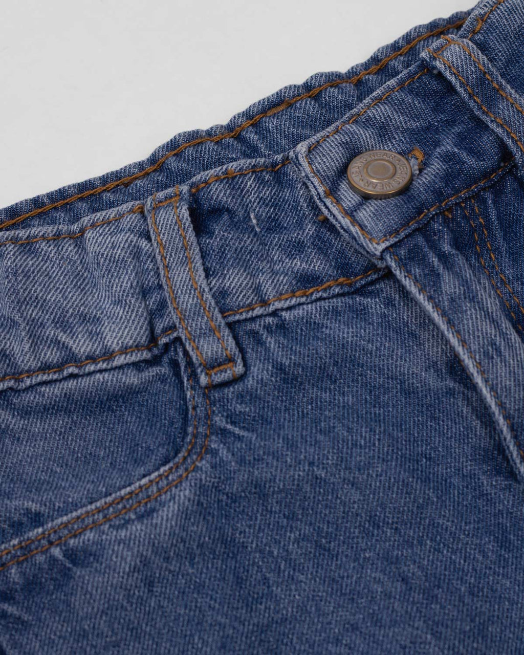 Jean denim marine fit con detalle de moños en la bota para niña