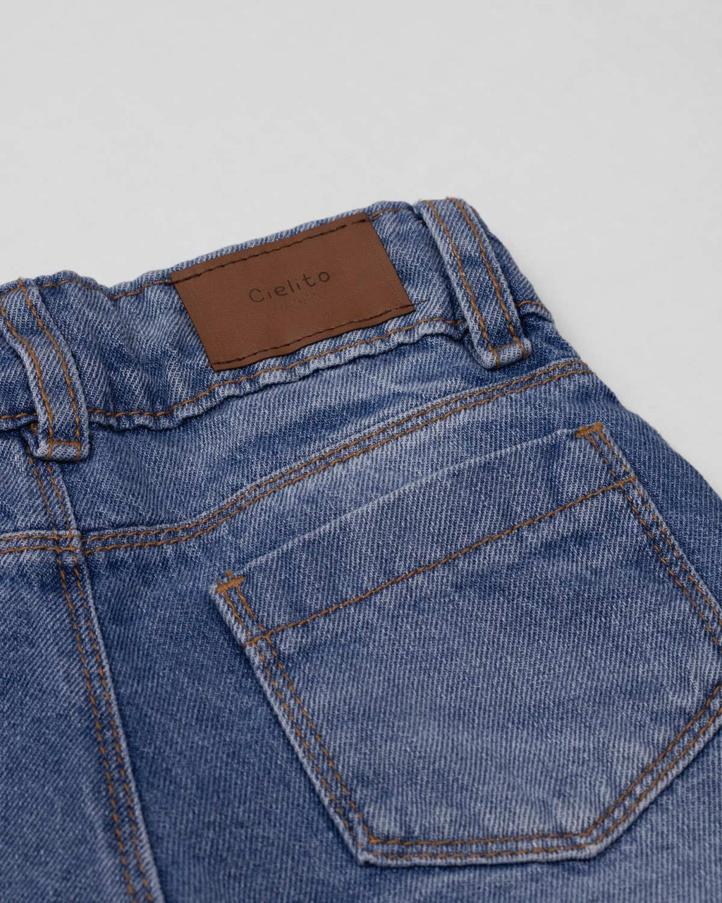 Jean denim marine fit con detalle de moños en la bota para niña