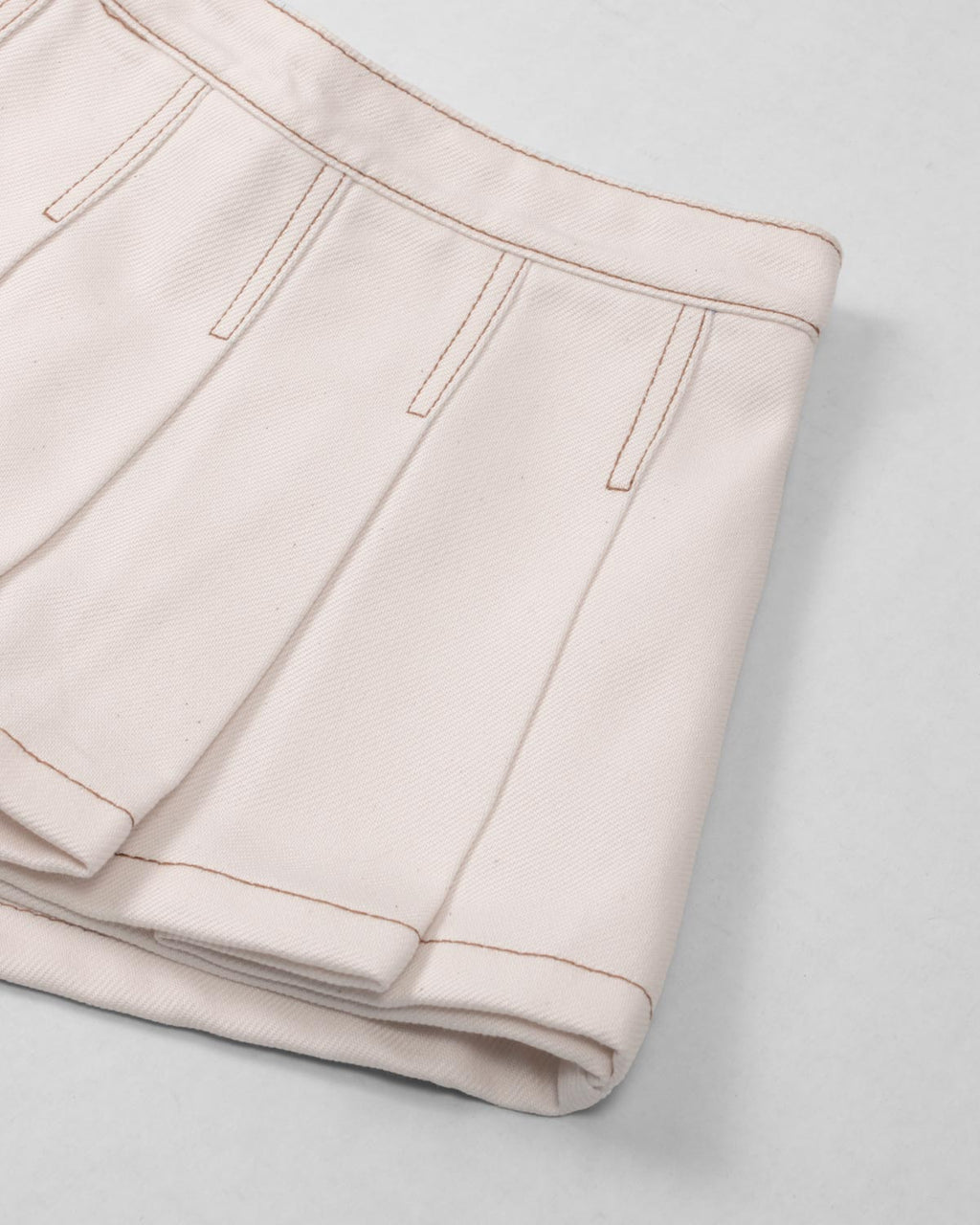 Falda short cruda con pliegues para niña