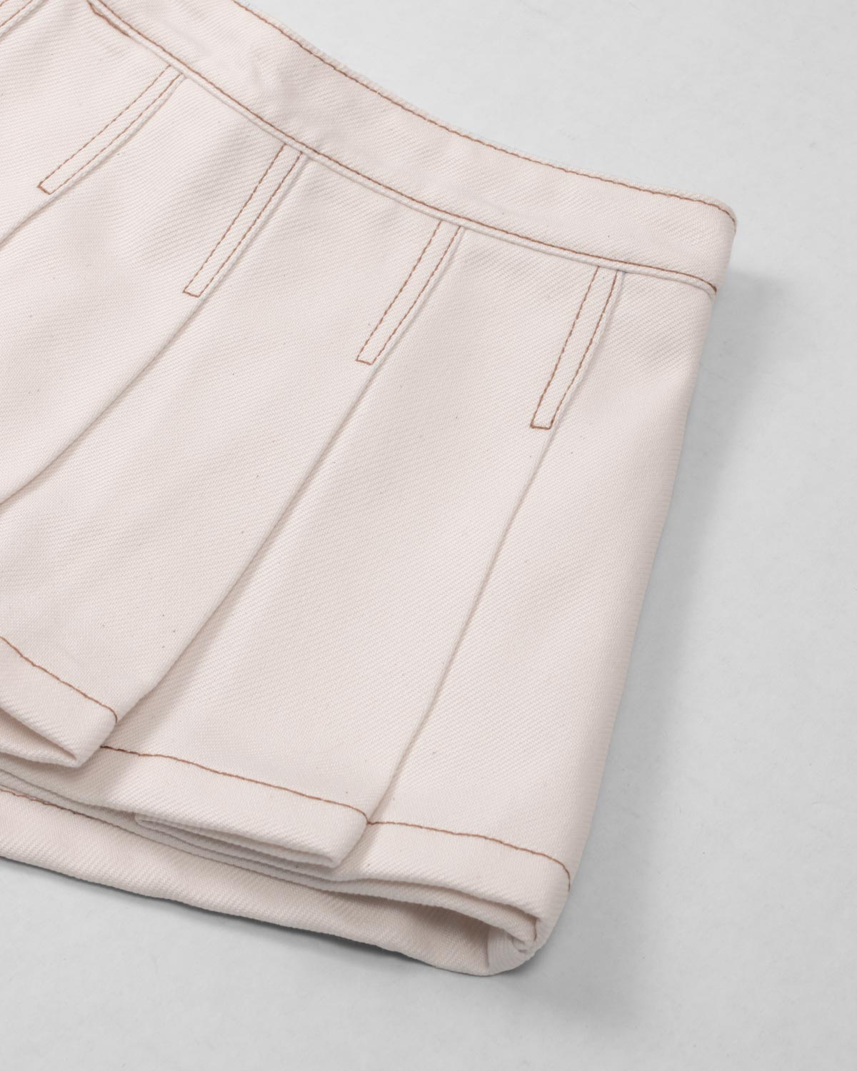 Falda short cruda con pliegues para niña