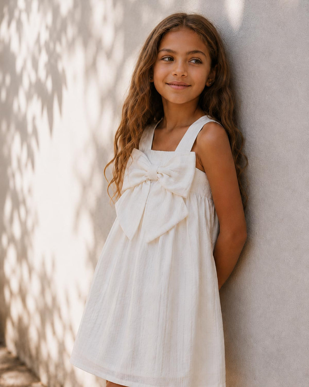 Vestido blanco con moño y líneas con brillos para niña
