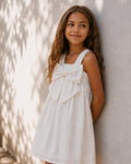 Vestido blanco con moño y líneas con brillos para niña