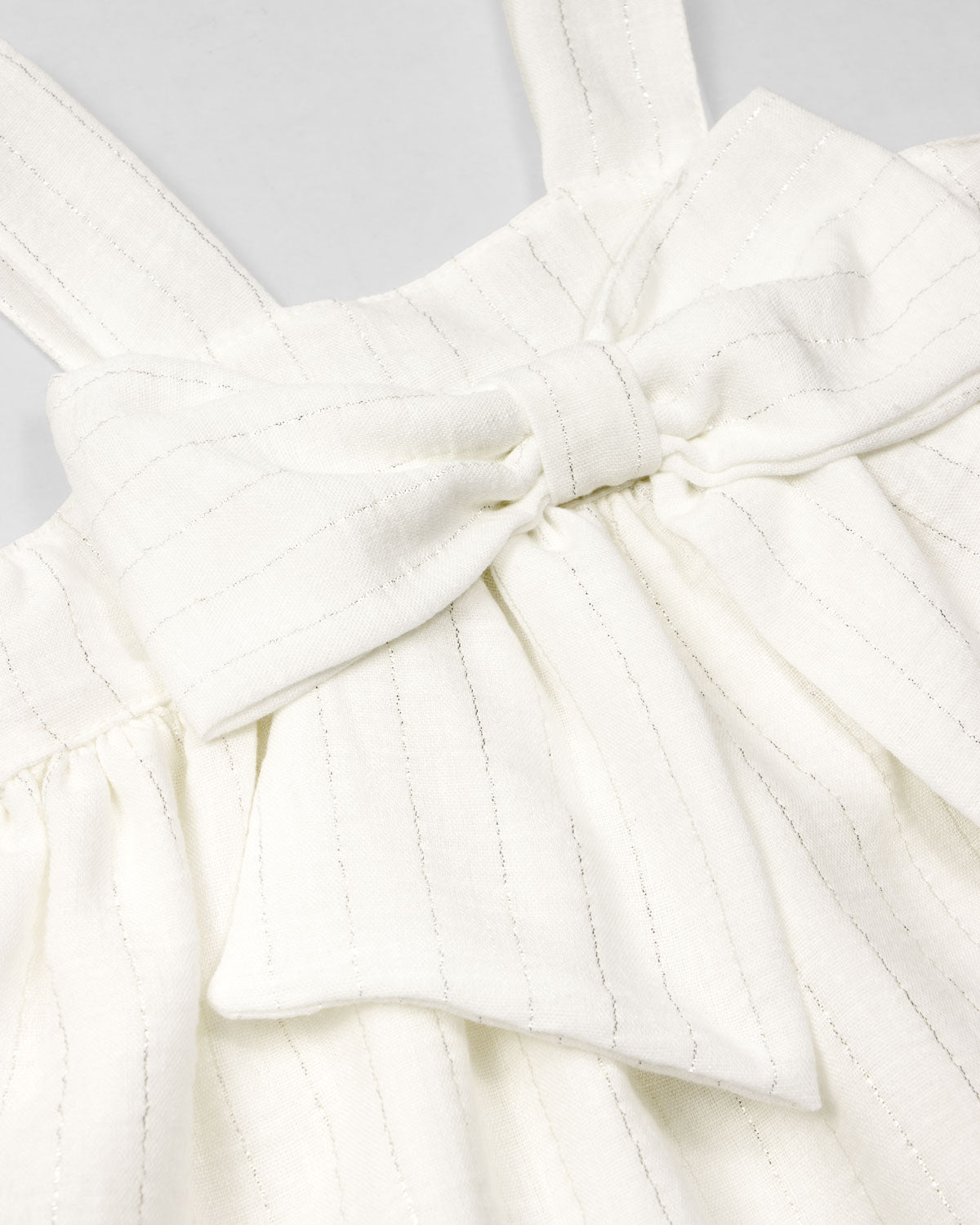 Vestido blanco con moño y líneas con brillos para niña