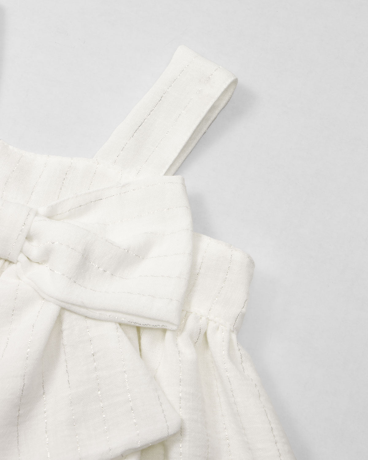Vestido blanco con moño y líneas con brillos para niña