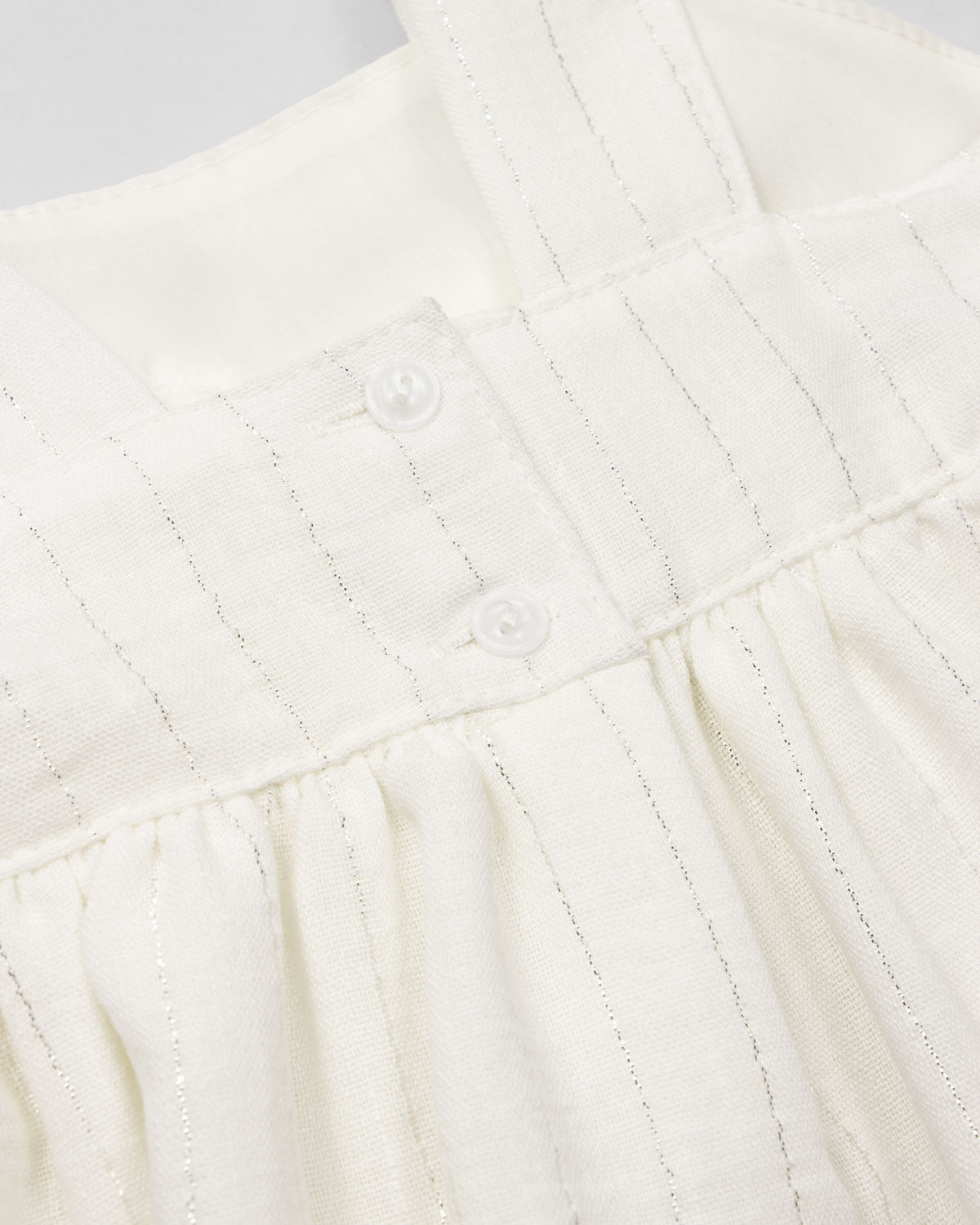 Vestido blanco con moño y líneas con brillos para niña