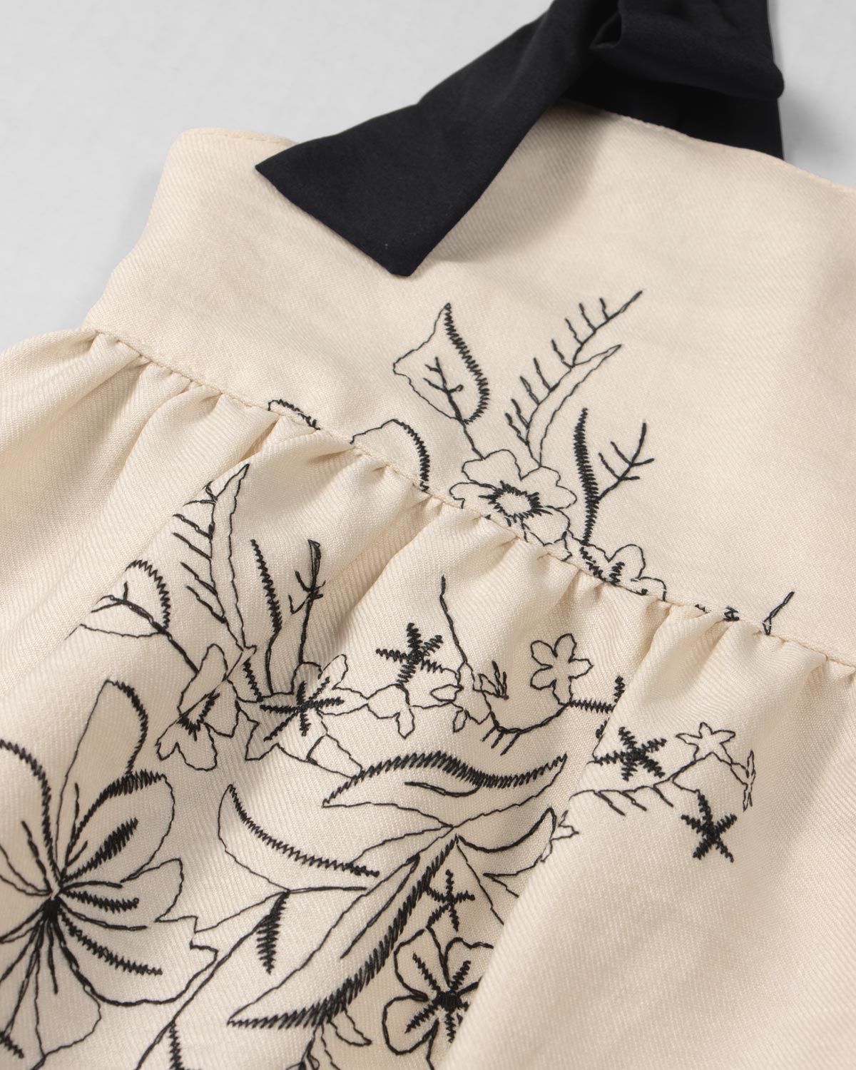 Vestido crema con diseño de flores tejido y tiras con moño para niña