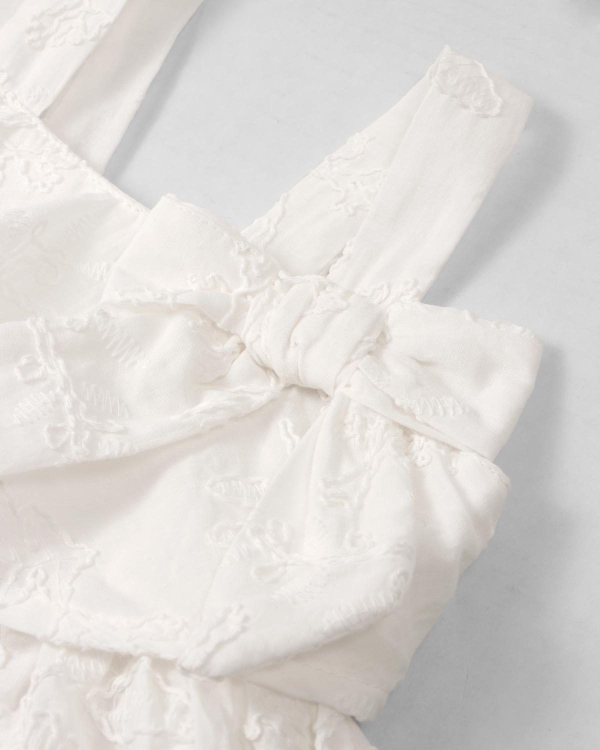 Vestido blanco de tiras con moño y tela bordada para niña