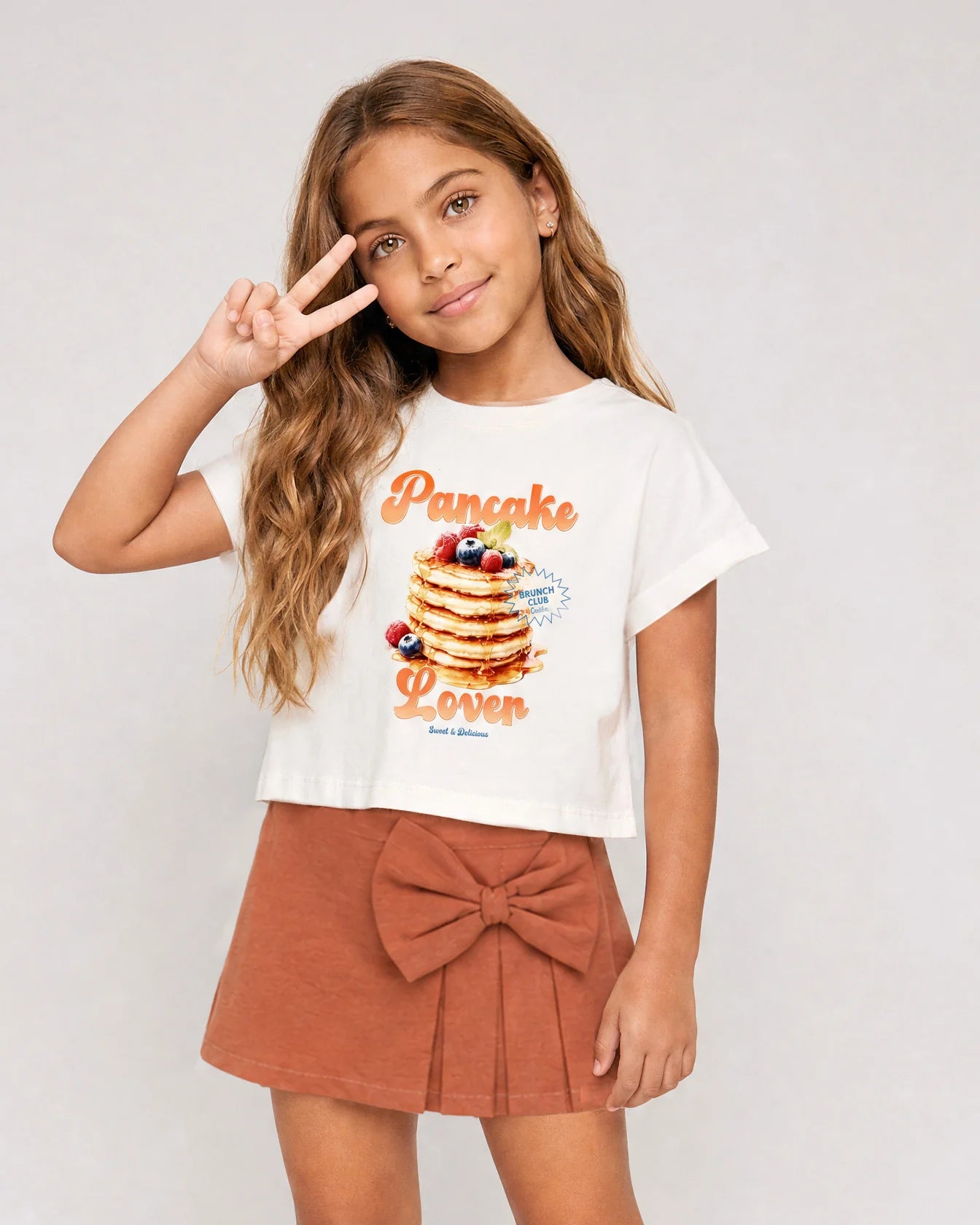 Conjunto blusa blanca con estampado Pancake y falda short con moño para niña
